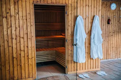 a wooden sauna with towels hanging on a wooden wall at Bowfield Hotel and Spa in Howwood
