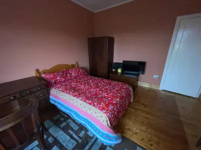 a bedroom with a bed with a red comforter at Lovely double room in very good area in Edinburgh