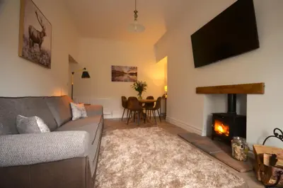 a living room with a couch and a fireplace at The Gate Lodge in Helensburgh