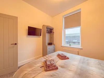 a bedroom with a bed with two towels on it at Barassie, Troon in Troon