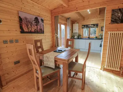 a dining room with a table and chairs in a cabin at Little Lodge in Newton Stewart