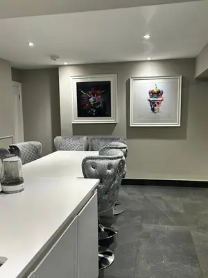 a room with a white counter and some chairs at Large Modern Family Home in Murrayfield - Very close to City Centre - 10 mins by Direct Bus - Private Driveway & Garden in Edinburgh