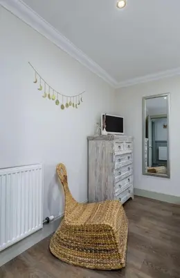 a living room with a chair and a mirror at The Tranquil Auchterarder 3-bed Cottage in Auchterarder