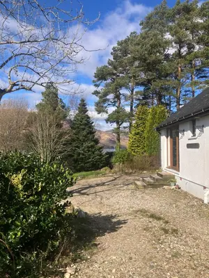 a path leading to a house with trees in the background at Fuaim Na Mara, The Sound Of The Sea. in Fort William
