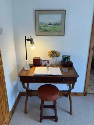 a wooden desk with a lamp and a chair at Fuaim Na Mara, The Sound Of The Sea. in Fort William