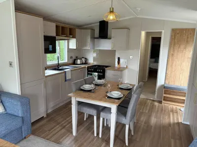 a kitchen and dining room with a table and chairs at Campsie Glen Holiday Park in Glasgow