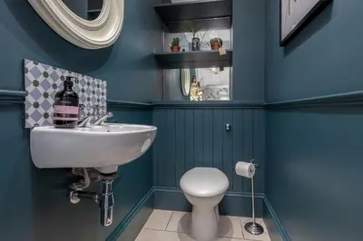 a bathroom with blue walls and a sink and a toilet at Beautiful Victorian Apartment close to the Botanical gardens, Free parking! in Edinburgh