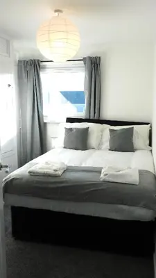 a bedroom with a large bed with a window at No 54 - New & delightful 3 bed house in East Kilbride in Glasgow