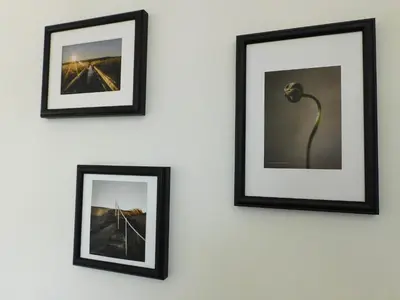 three framed pictures on a wall with a lamp at No 54 - New & delightful 3 bed house in East Kilbride in Glasgow