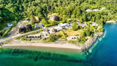 an aerial view of a house on an island in the water at Onich Hotel & Lochside Beach Pods in Onich