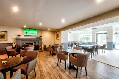 a restaurant with tables and chairs and a fireplace at Onich Hotel & Lochside Beach Pods in Onich
