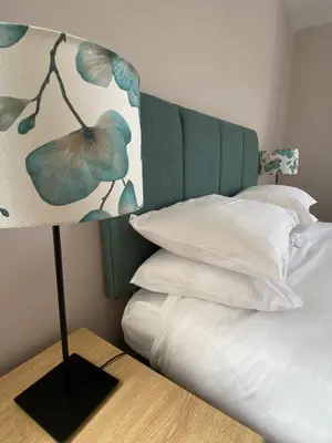 a bed with a headboard and a lamp on a table at Bunessan Inn in Bunessan