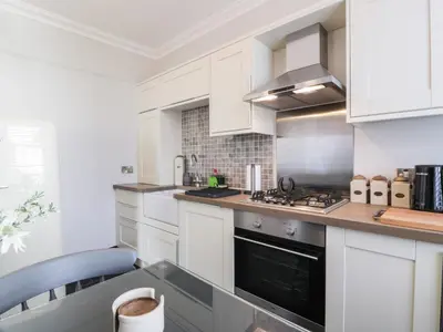 a kitchen with white cabinets and a stove top oven at Lower Neuk in Dunfermline