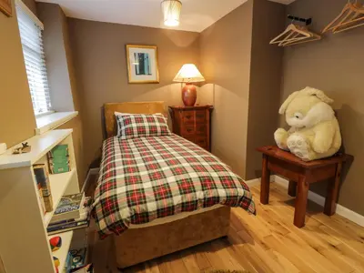 a teddy bear sitting on a table in a bedroom at Lower Neuk in Dunfermline