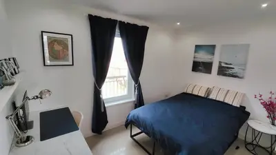 a bedroom with a blue bed and a window at La Casita, Your Home Away from Home - Free Parking in Glasgow