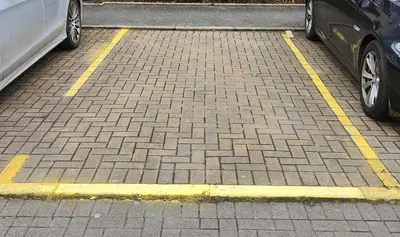 two cars parked in a parking lot with yellow lines at La Casita, Your Home Away from Home - Free Parking in Glasgow