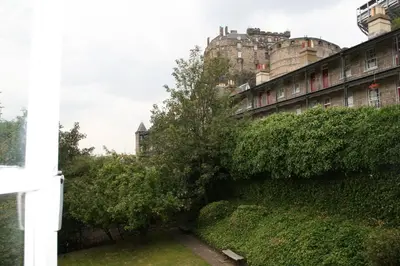 a tree is leaning against a wall in front of a building at Grassmarket Studio in Edinburgh