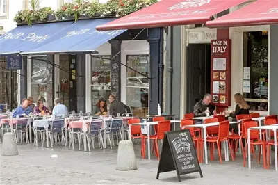 a group of people sitting at tables outside a restaurant at Grassmarket Studio in Edinburgh