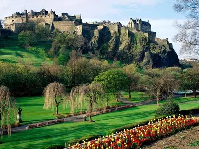 a castle on top of a hill with flowers at Grassmarket Studio in Edinburgh