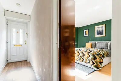 a bedroom with a bed and a green wall at Spacious 2-Bedroom Main Door Apartment With Private Parking in Glasgow