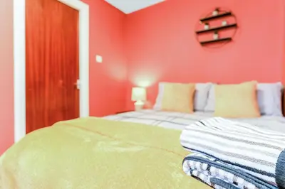 a bedroom with red walls and a bed at Spacious 2-Bedroom Main Door Apartment With Private Parking in Glasgow