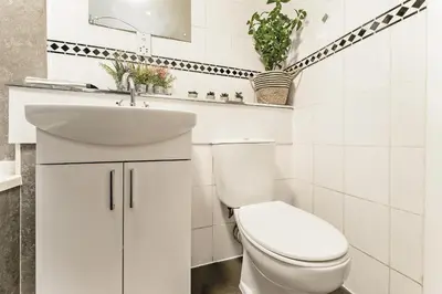 a white bathroom with a toilet and a sink at Spacious 2-Bedroom Main Door Apartment With Private Parking in Glasgow
