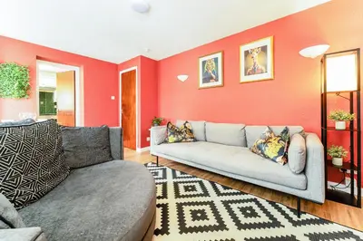 a living room with red walls and a couch at Spacious 2-Bedroom Main Door Apartment With Private Parking in Glasgow