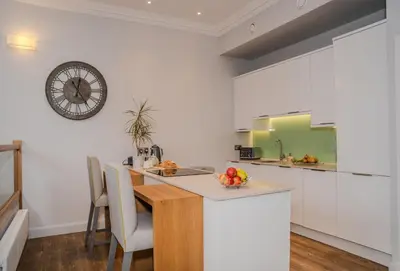a kitchen with a table and a clock on the wall at The Kinross Residence in Kinross