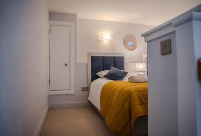 a bedroom with a bed with a yellow blanket at The Kinross Residence in Kinross