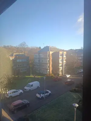 a parking lot with cars parked in front of buildings at Open space studio in Shawlands in Glasgow