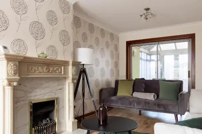 a living room with a couch and a fireplace at Gunn House in Grangemouth