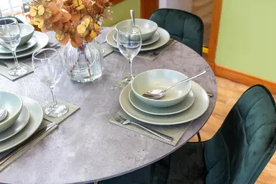 a table with white plates and silverware on it at Gunn House in Grangemouth