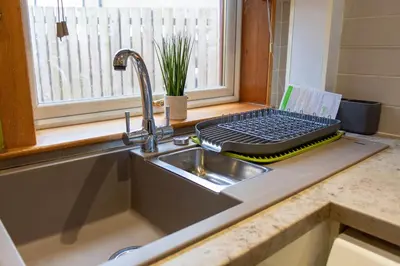 a kitchen counter with a sink and a keyboard on a window at Gunn House in Grangemouth