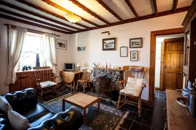 a living room with a couch and a table and chairs at Seaview Cottage in Isle of Jura