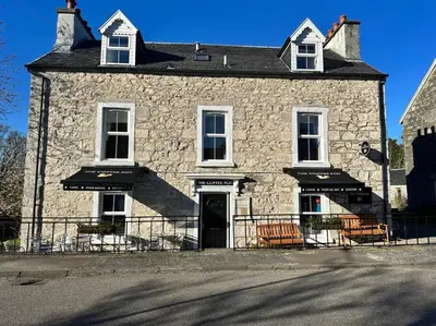 an old stone building with chairs in front of it at Argyll House Burnside in Salen