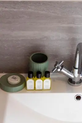 a sink with three bottles of essential oils next to a faucet at Winton House in Glasgow