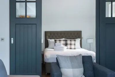a bedroom with a bed and a blue couch at Cool urban apartment with stunning Castle views in Edinburgh