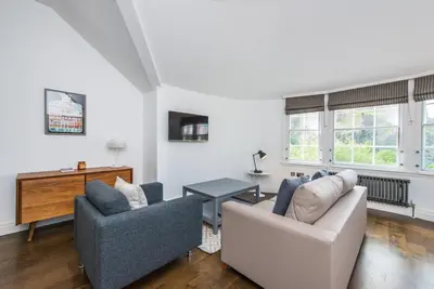 a living room with two couches and a table at Cool urban apartment with stunning Castle views in Edinburgh