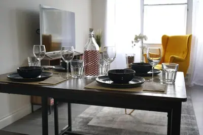 a table with wine glasses and a bottle on it at Falkirk City Centre Stylish Two-Bedrooms Apartment in Falkirk