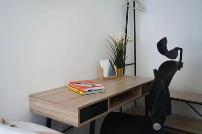 a desk with a black chair and a wooden table at Falkirk City Centre Stylish Two-Bedrooms Apartment in Falkirk