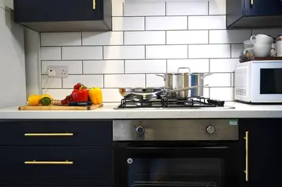 a kitchen with a stove and a microwave at Falkirk City Centre Stylish Two-Bedrooms Apartment in Falkirk