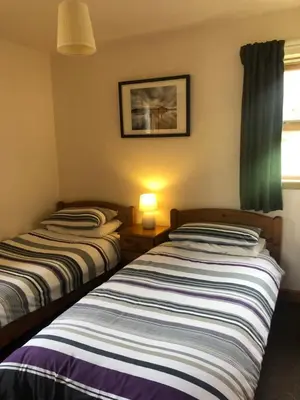 two beds sitting next to each other in a room at Bracken Lodges, Loch Tay, Linnie Lodge in Aberfeldy