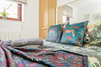 a bed with colorful blankets and pillows on it at The Merchants Gem - 2Bed & Free Parking in Glasgow
