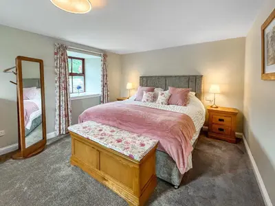 a bedroom with a large bed and a mirror at The Clachan Bothy in Drumpark