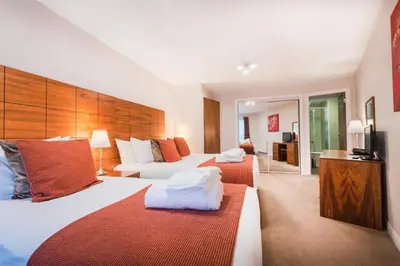 a hotel room with two beds and a television at The Knight Residence by Mansley in Edinburgh
