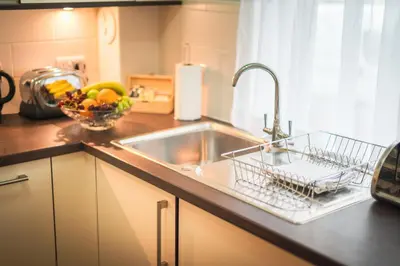 a kitchen counter with a sink and a bowl of fruit at The Knight Residence by Mansley in Edinburgh