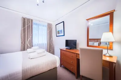 a bedroom with a bed and a desk and a mirror at The Knight Residence by Mansley in Edinburgh