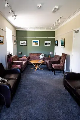 a living room with couches and a table at Lochranza Country Inn in Lochranza