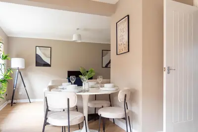 a dining room with a white table and chairs at Grove House in Queensferry
