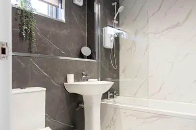 a bathroom with a sink and a shower and a toilet at Grove House in Queensferry